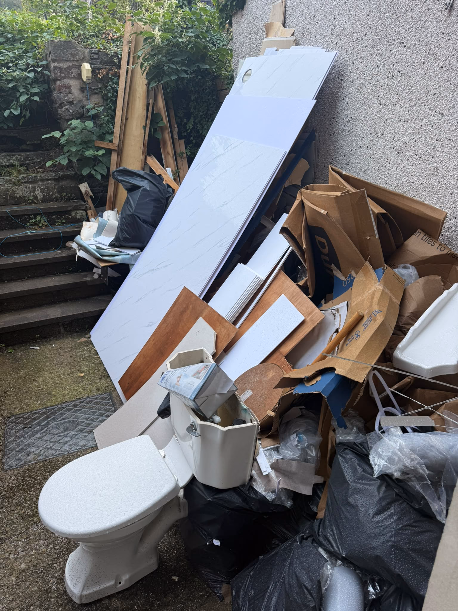 Before: old bathroom suite and household waste cleared from a rear garden