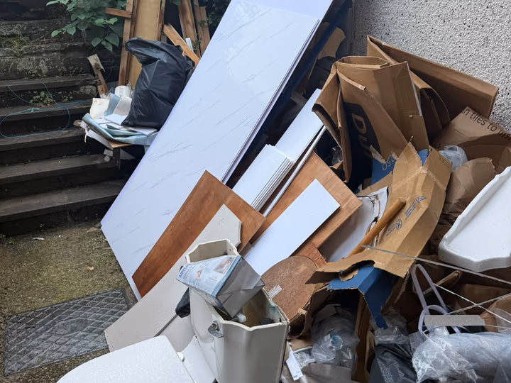 Before: old bathroom suite and household waste cleared from a rear garden