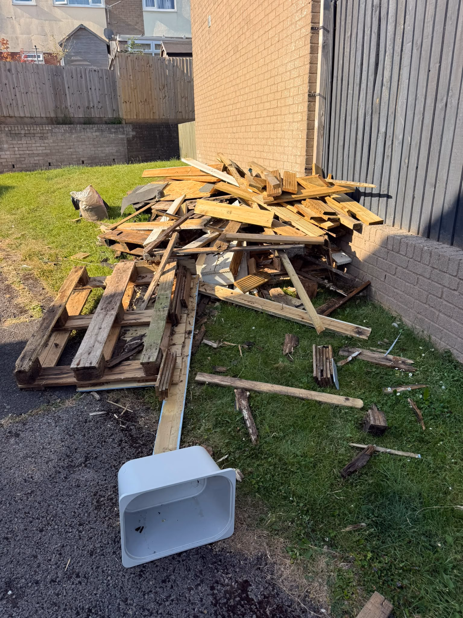 Before: pallets and scrap timber removed from a garden