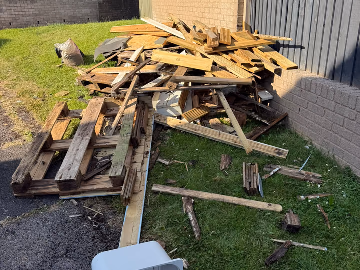 Before: pallets and scrap timber removed from a garden