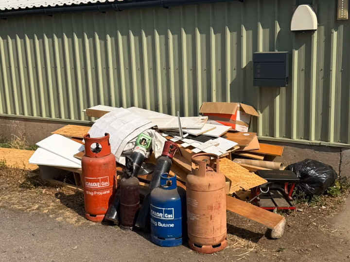 Before: mattress, cylinders and mixed waste cleared from a commercial yard