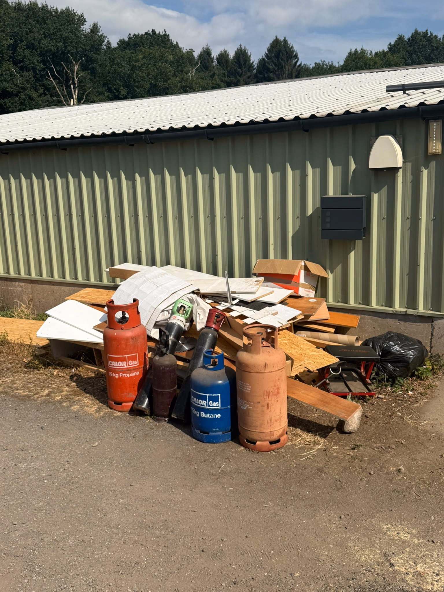 Before: mattress, cylinders and mixed waste cleared from a commercial yard