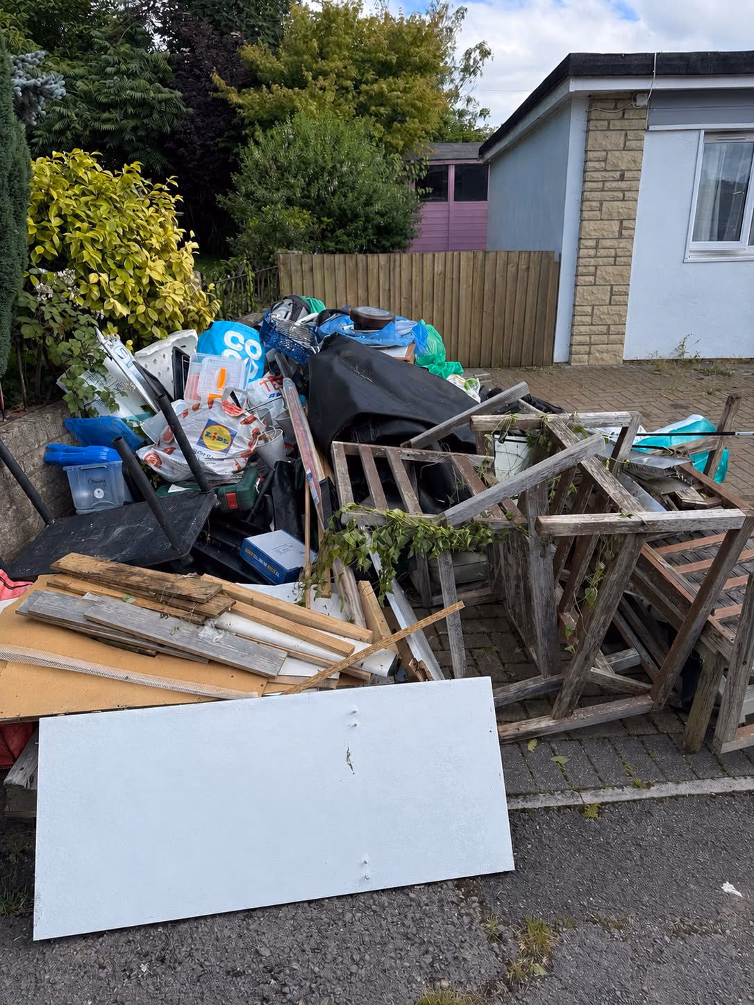 Before: mixed rubbish and fencing cleared from a driveway